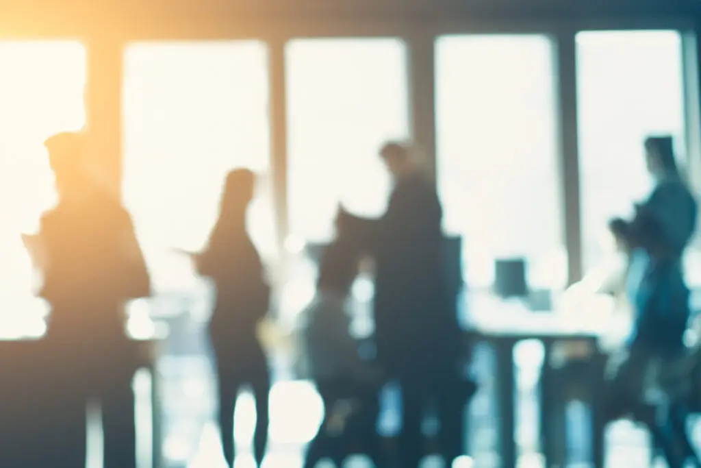 Mitarbeitende im Büro im Gegenlicht